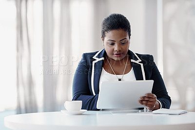 Buy stock photo Cropped shot of an attractive young businesswoman using her tablet while sitting in the office