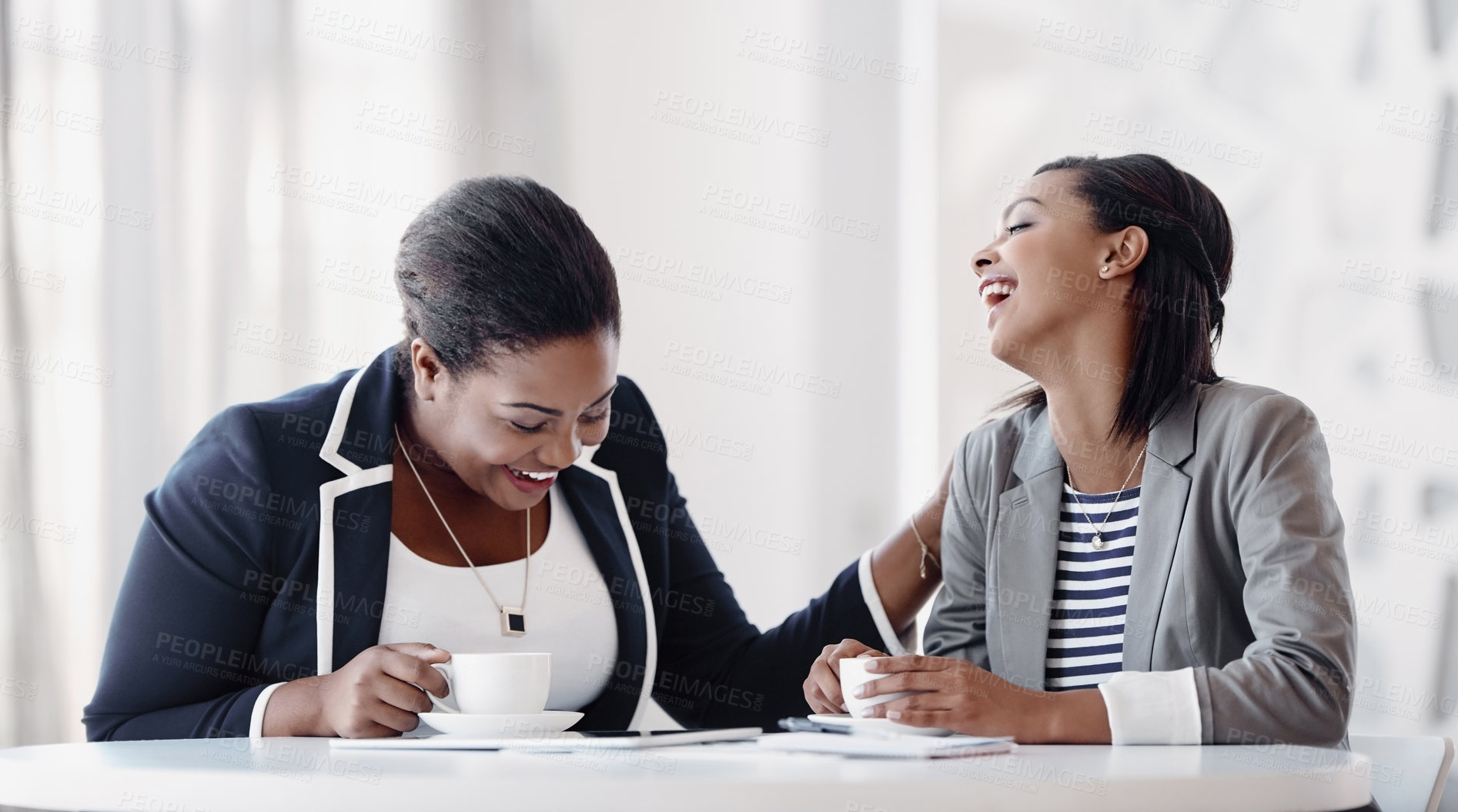 Buy stock photo Cropped shot of two attractive young businesswomen having a laugh while working together in their office