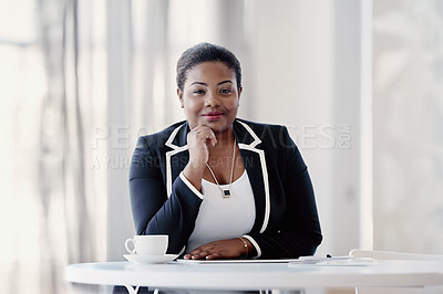 Buy stock photo Cropped portrait of an attractive young businesswoman sitting behind a desk in the office with her hand on her chin