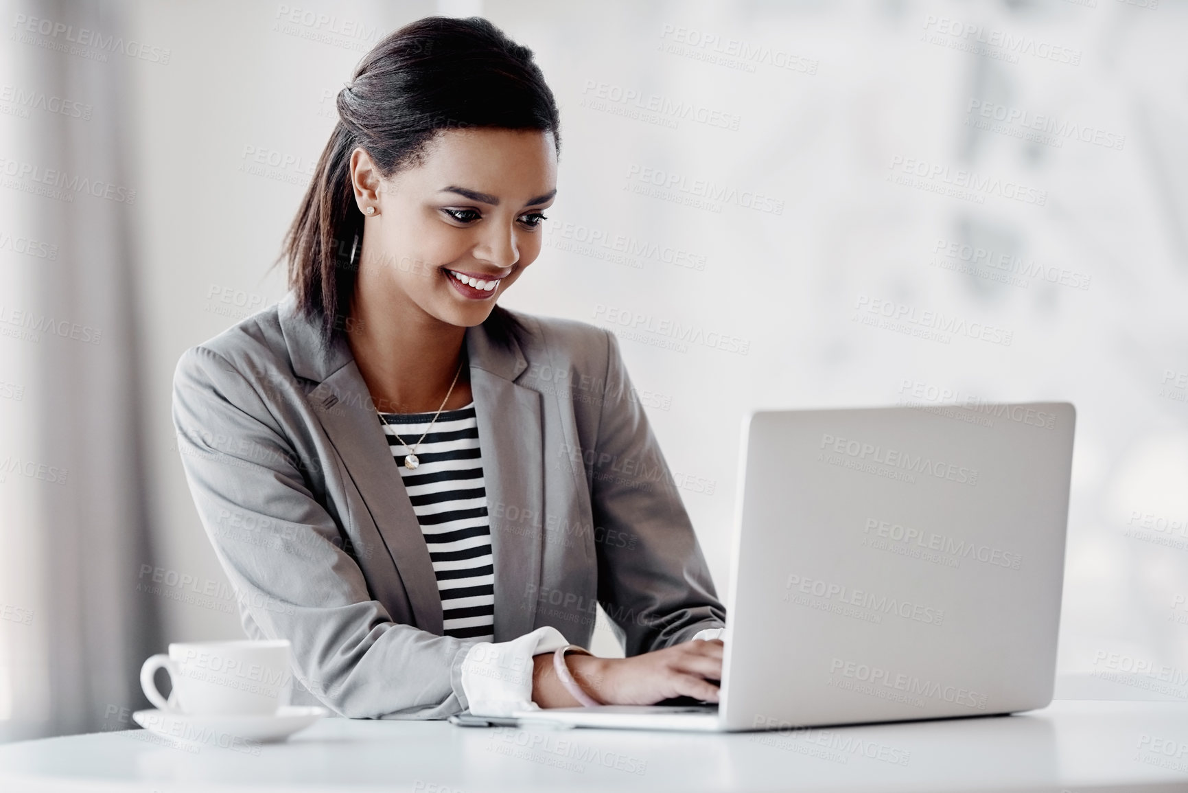 Buy stock photo Cropped shot of an attractive young businesswoman using her laptop while working in the office