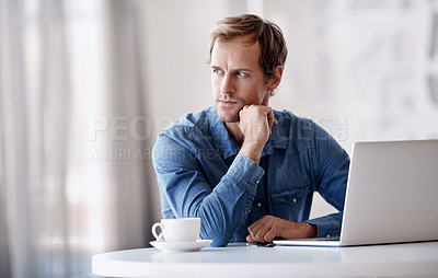 Buy stock photo Cropped shot of a handsome mature businessman looking thoughtful while working on his laptop in the office
