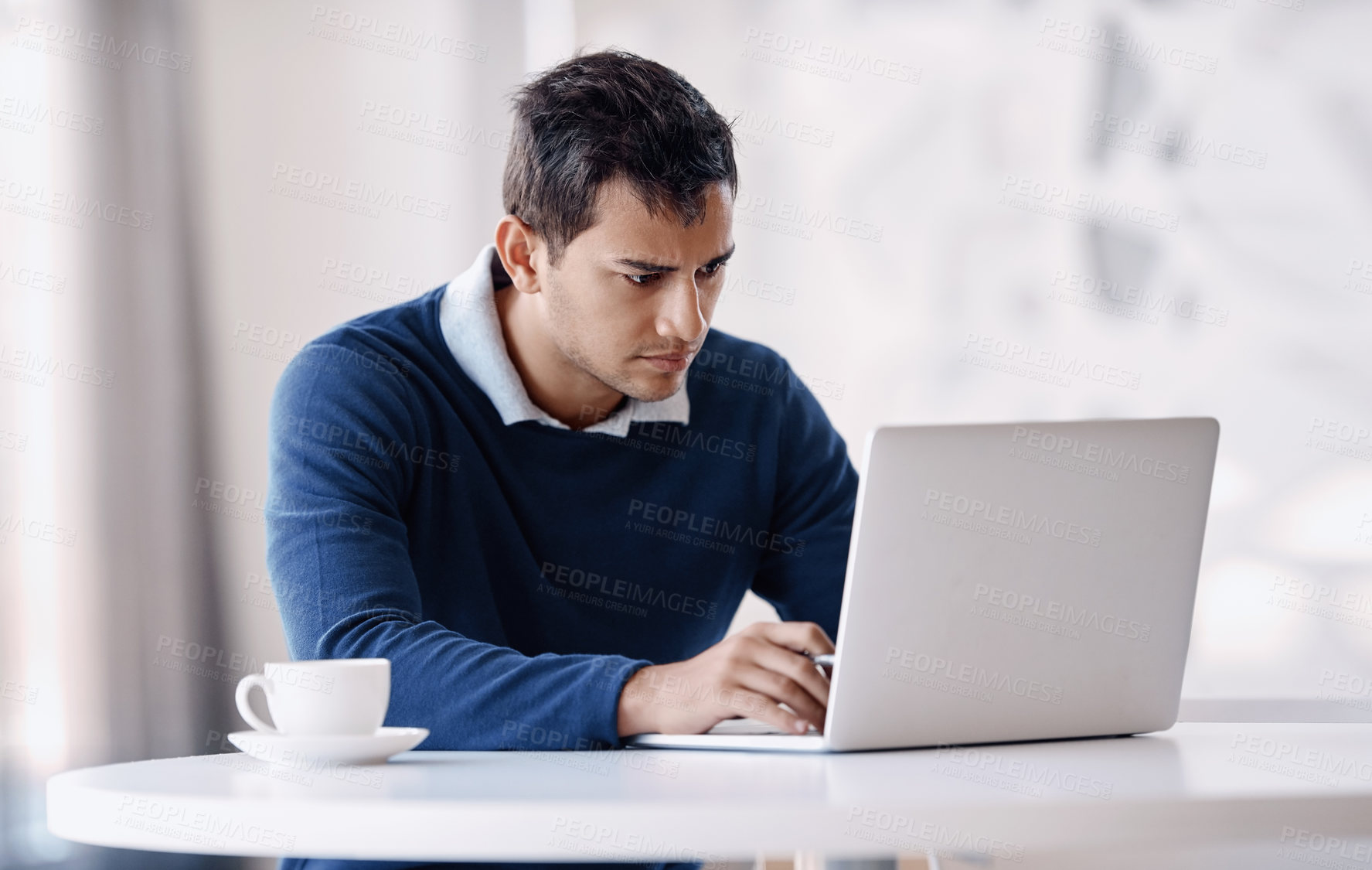 Buy stock photo Cropped shot of a handsome young businessman working on his laptop in the office