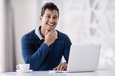 Buy stock photo Cropped portrait of a handsome young businessman looking thoughtful while working on his laptop in the office