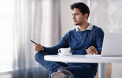 Buy stock photo Cropped shot of a handsome young businessman looking thoughtful while sitting behind his desk in the office