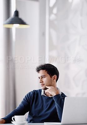 Buy stock photo Cropped shot of a handsome young businessman looking thoughtful while sitting behind his desk in the office
