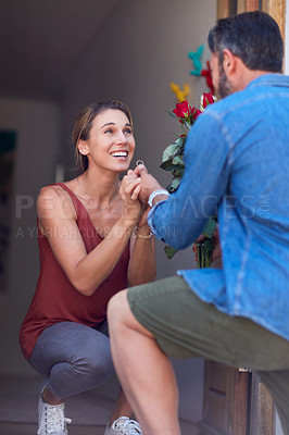 Buy stock photo Cropped shot of an attractive young woman accepting a marriage proposal on her doorway at home