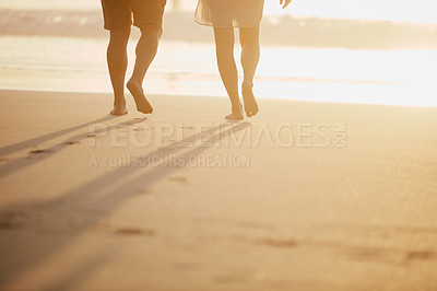 Buy stock photo Cropped shot of an unrecognizable couple walking on the beach