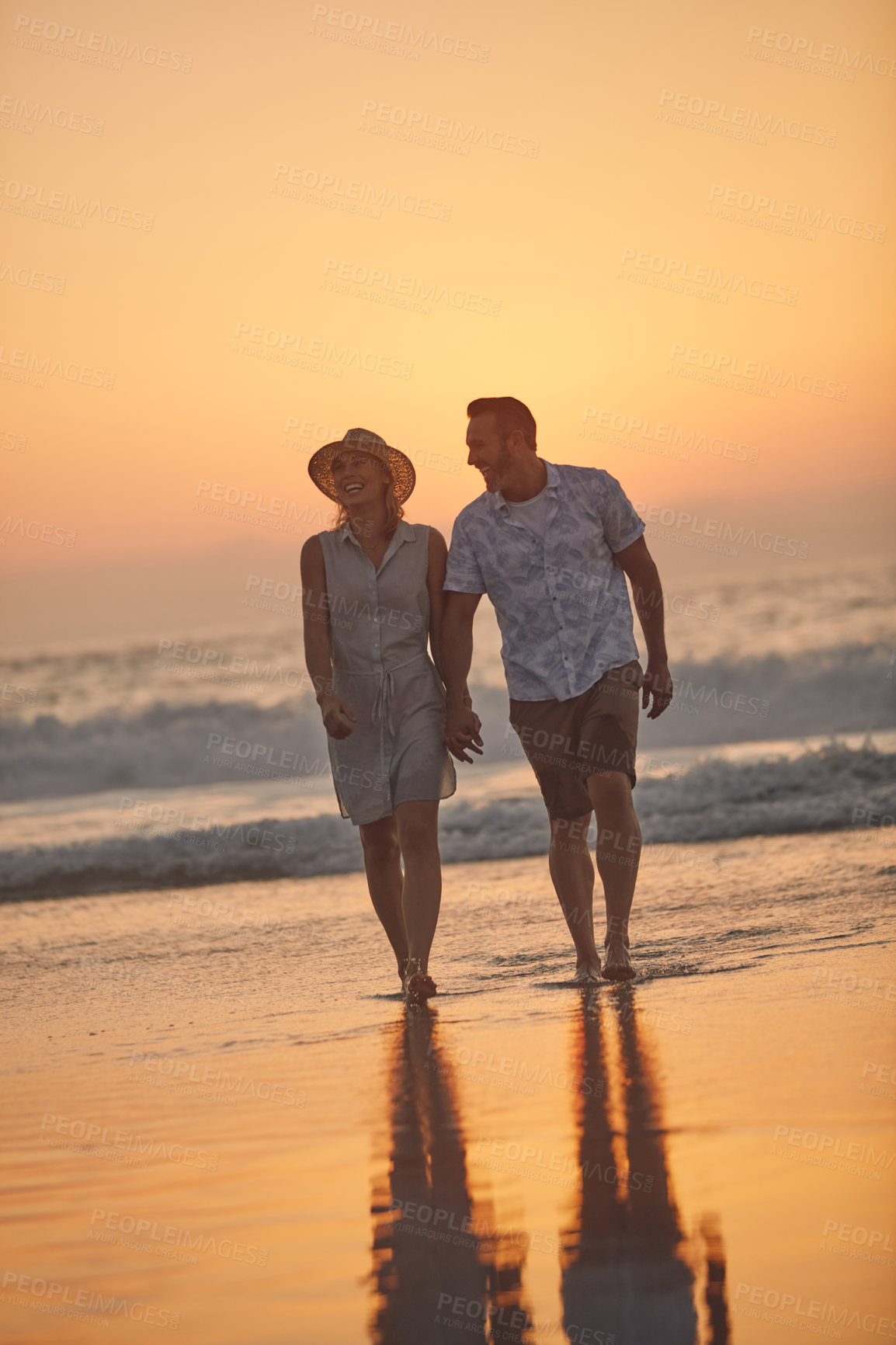 Buy stock photo Shot of an affectionate mature couple taking a walk on the beach