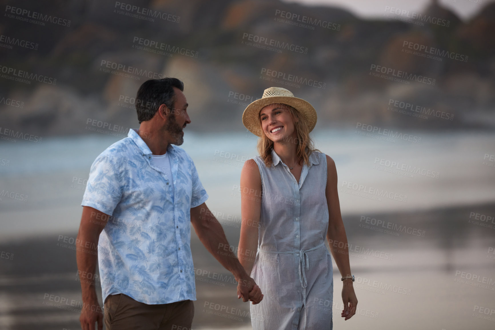 Buy stock photo Shot of an affectionate mature couple taking a walk on the beach