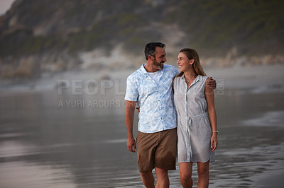 Buy stock photo Shot of an affectionate mature couple taking a walk on the beach