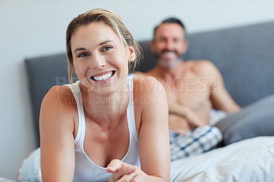 Buy stock photo Portrait of an attractive young woman looking happy in the bedroom with her husband in the background