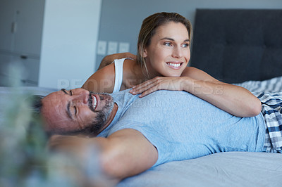 Buy stock photo Cropped shot of an attractive young woman lying on her husband's chest in their bedroom