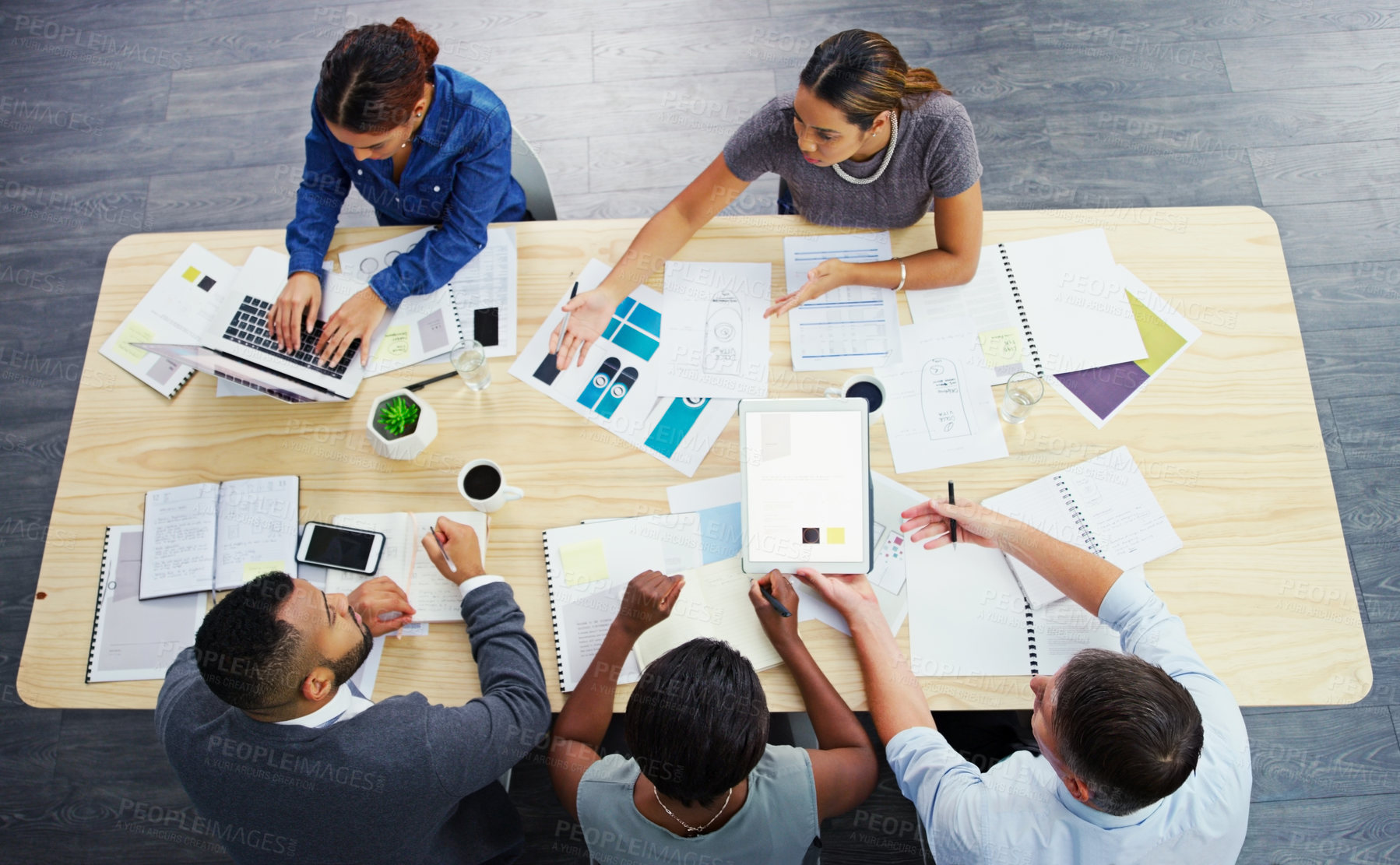 Buy stock photo High angle shot of a group of businesspeople having a meeting around a table at work