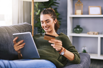 Buy stock photo Shot of a beautiful young woman using a digital tablet and credit card to do some online shopping at home