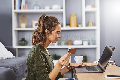 Buy stock photo Shot of a beautiful young woman using a laptop and credit card to do some online shopping at home