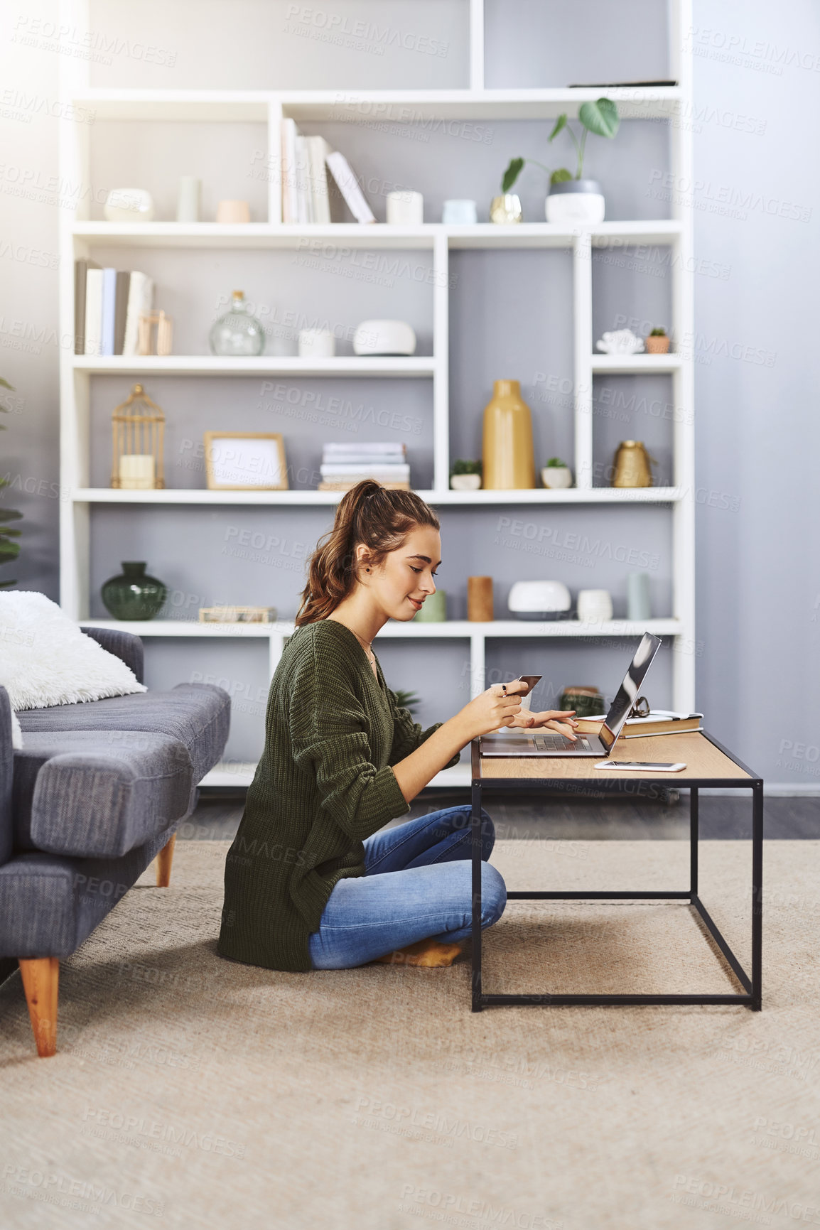 Buy stock photo Full length shot of a young woman using a laptop and credit card to do some online shopping at home