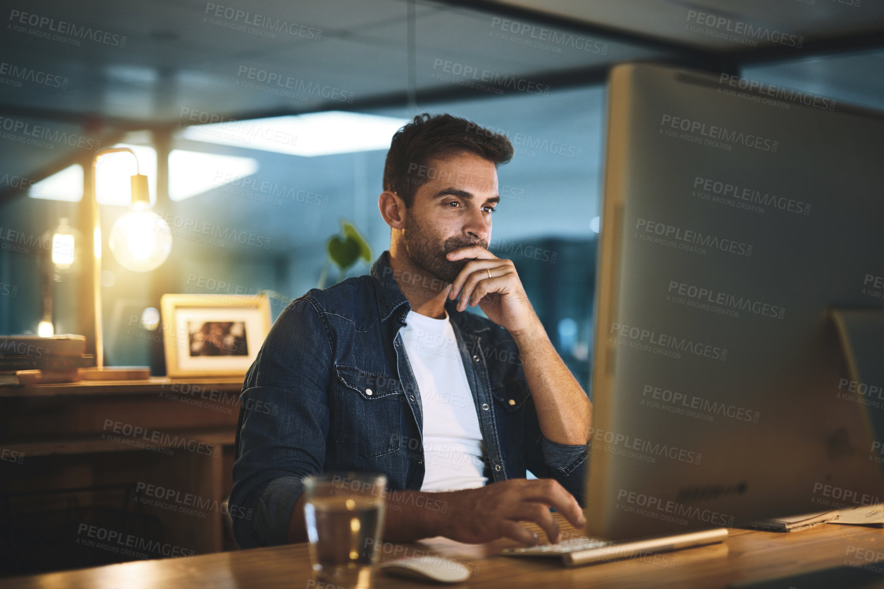 Buy stock photo Computer, night and man in office with reading for software development and troubleshooting of system. Research, technology and male IT specialist working overtime with online firewall configuration.