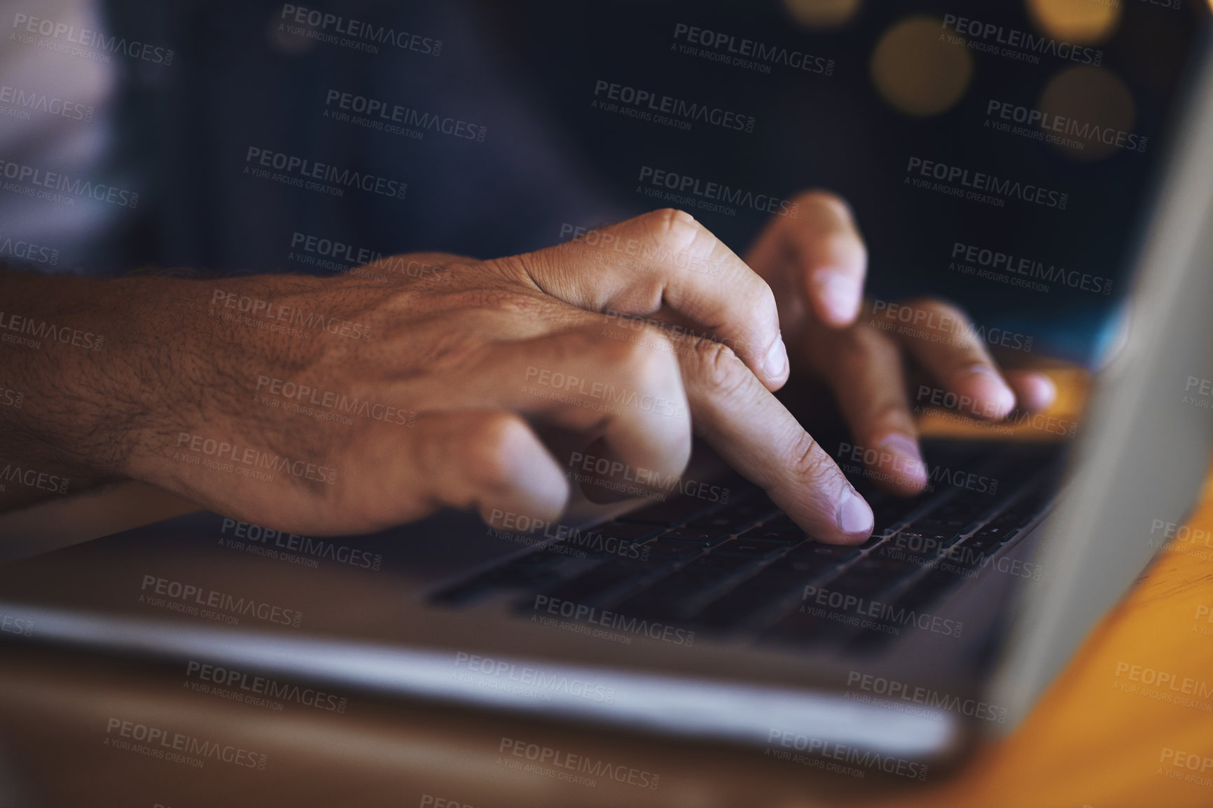 Buy stock photo Shot of an unrecognised businessman working late at night on his computer in a modern office