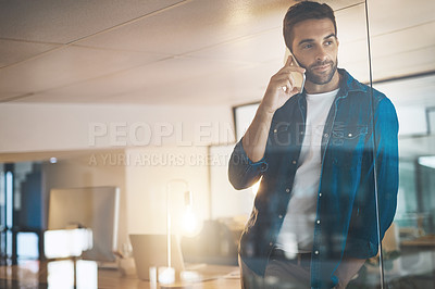 Buy stock photo Cropped shot of a businessman talking on his cellphone while standing in his office