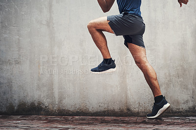 Buy stock photo Closeup shot of an unrecognizable man running against a grey wall outdoors