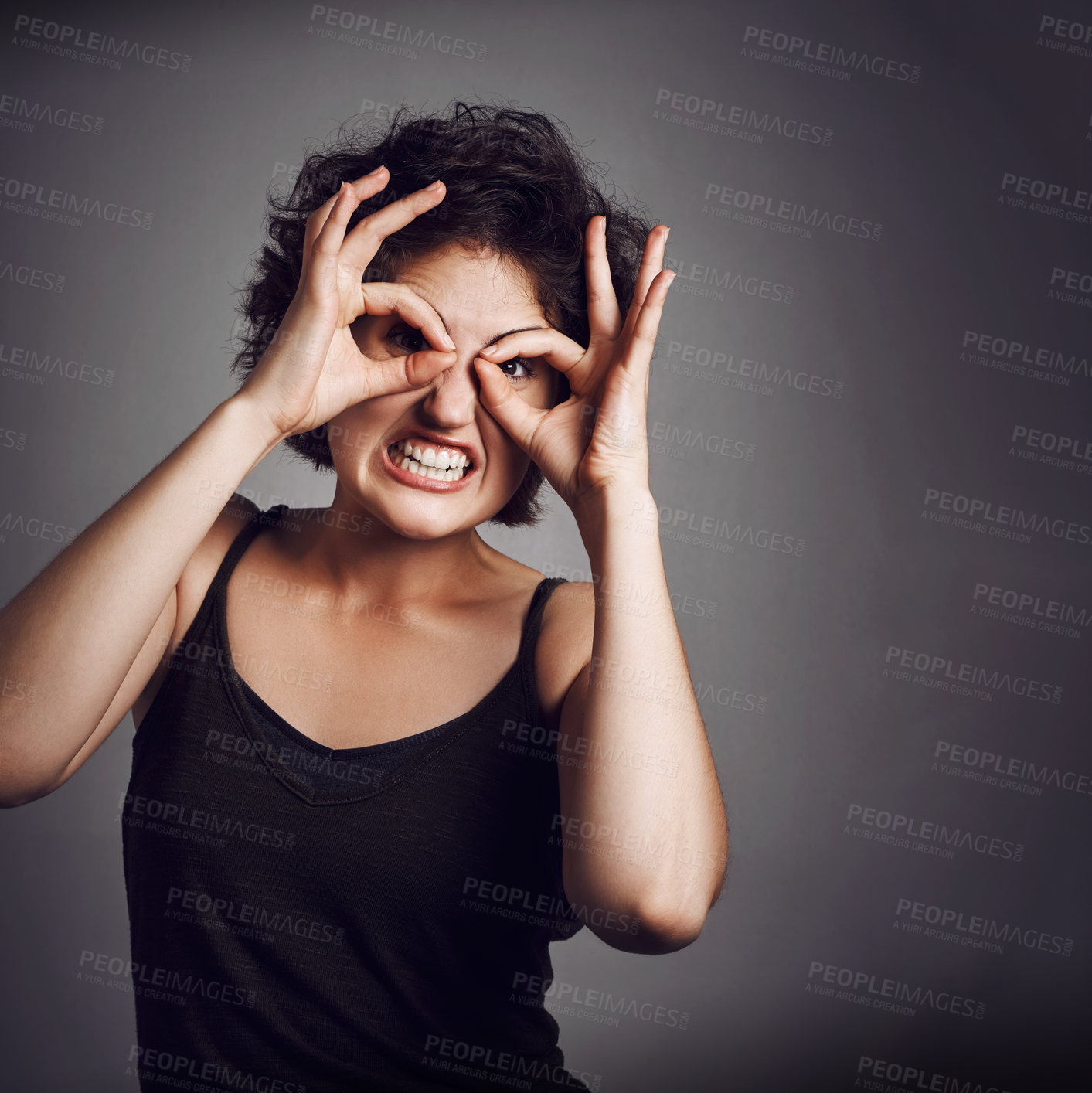 Buy stock photo Circle on eyes, funny face and portrait of woman in studio for facial expression, excited and emoji reaction. Comic, humor and isolated person with joke, silly pose and crazy on dark background