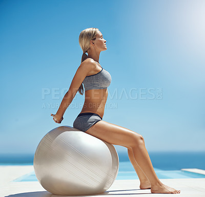 Buy stock photo Full length shot of an attractive young woman stretching by the pool after her workout on a sunny day