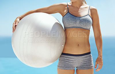 Buy stock photo Cropped shot of an unrecognisable young woman holding an exercise ball after her workout by the pool