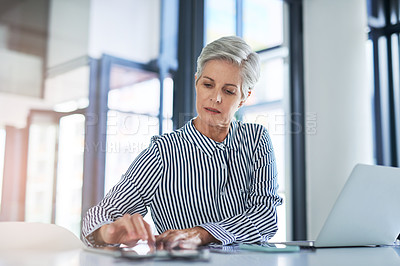 Buy stock photo Shot of an attractive mature businesswoman using a laptop at her office desk at work