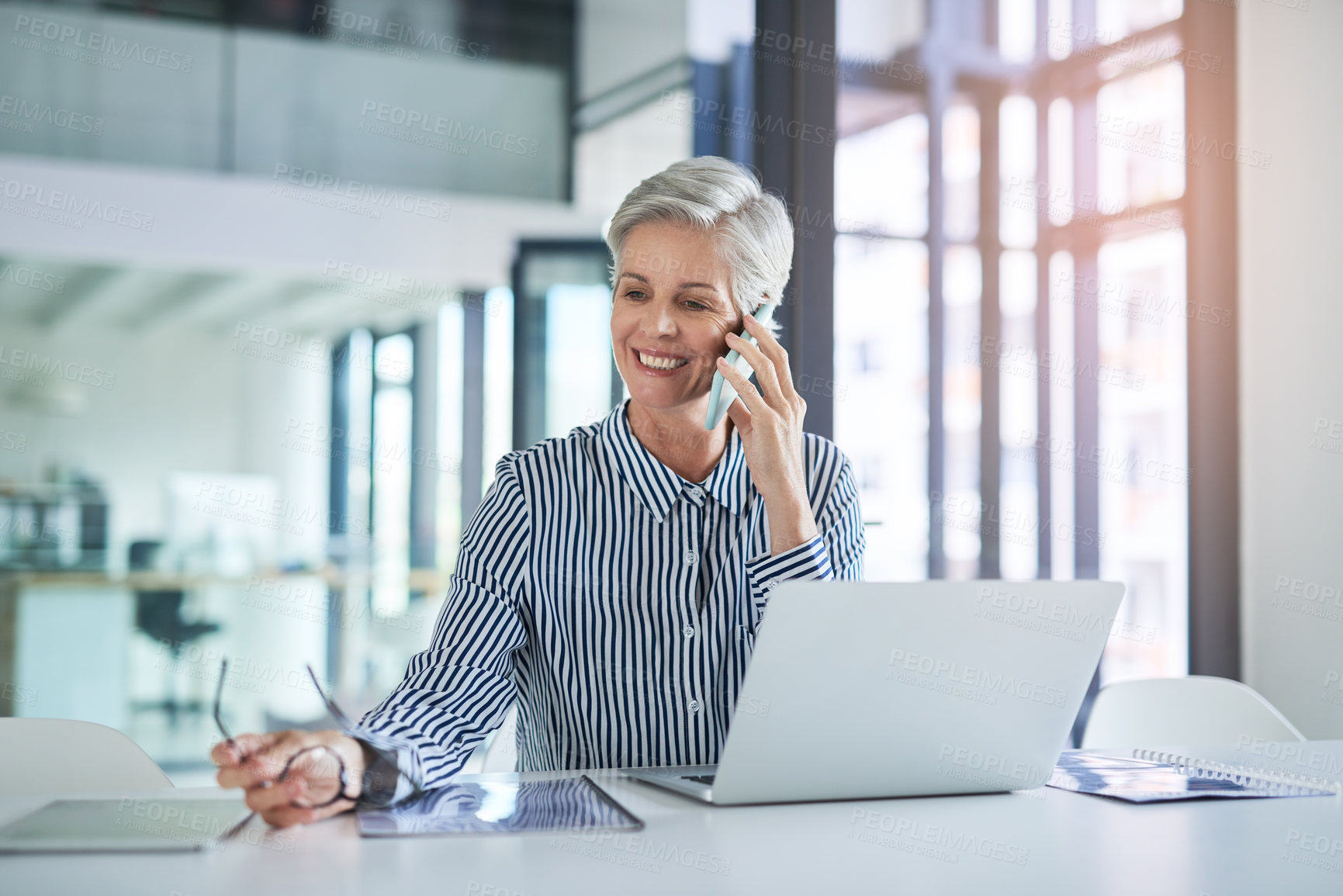 Buy stock photo Shot of an attractive mature businesswoman taking a phone call at her office desk at work