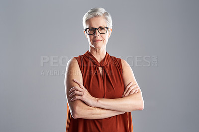 Buy stock photo Portrait of an attractive mature businesswoman posing with her arms folded against a grey background