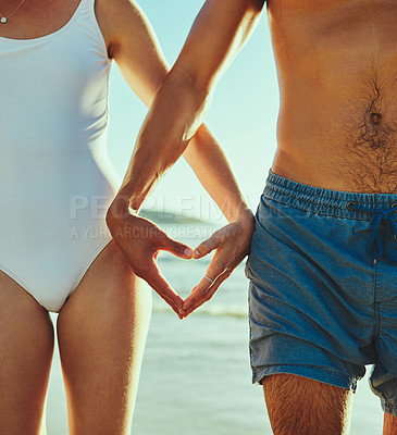 Buy stock photo Closeup shot of a couple making a heart shape with their hands at the beach