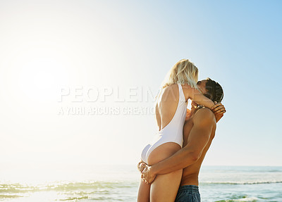 Buy stock photo Shot of an affectionate young couple kissing each other at the beach