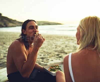 Buy stock photo Couple, happy and eating on beach for picnic, love and milestone in relationship at sunset. Man, woman or sharing food at ocean for bonding, summer vacation or pizza in evening on sand in Australia