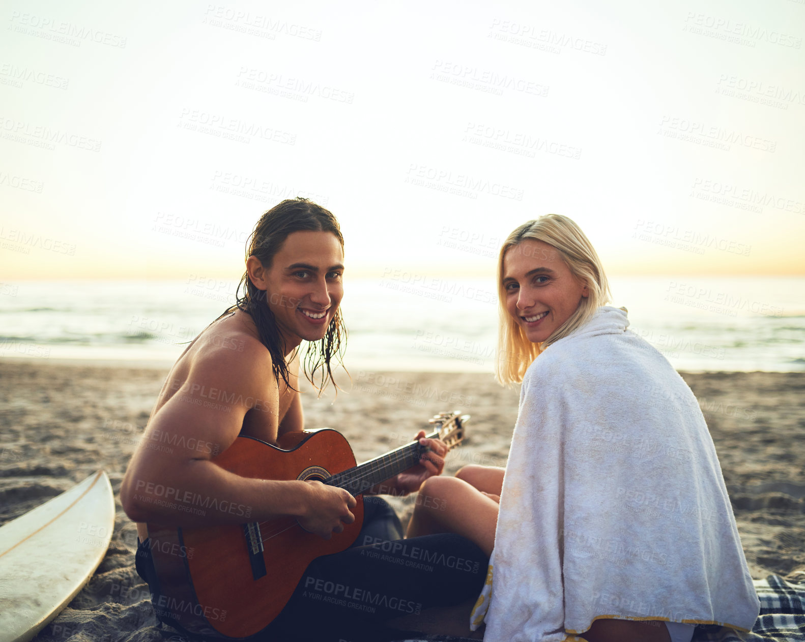 Buy stock photo Rearview portrait of a smiling young couple during their date on the beach at sunset