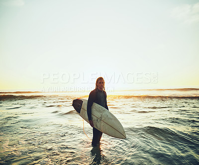 Buy stock photo Portrait of a young man carrying a surfboard at the beach