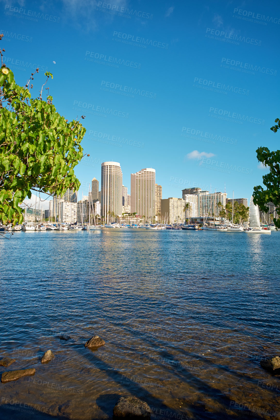 Buy stock photo Apartments or business district beside a lagoon beach on a sunny day with a cloudy blue sky in Waikiki. A popular summer vacation tourist location in Oahu, Hawaii. Luxury resort by the ocean in USA