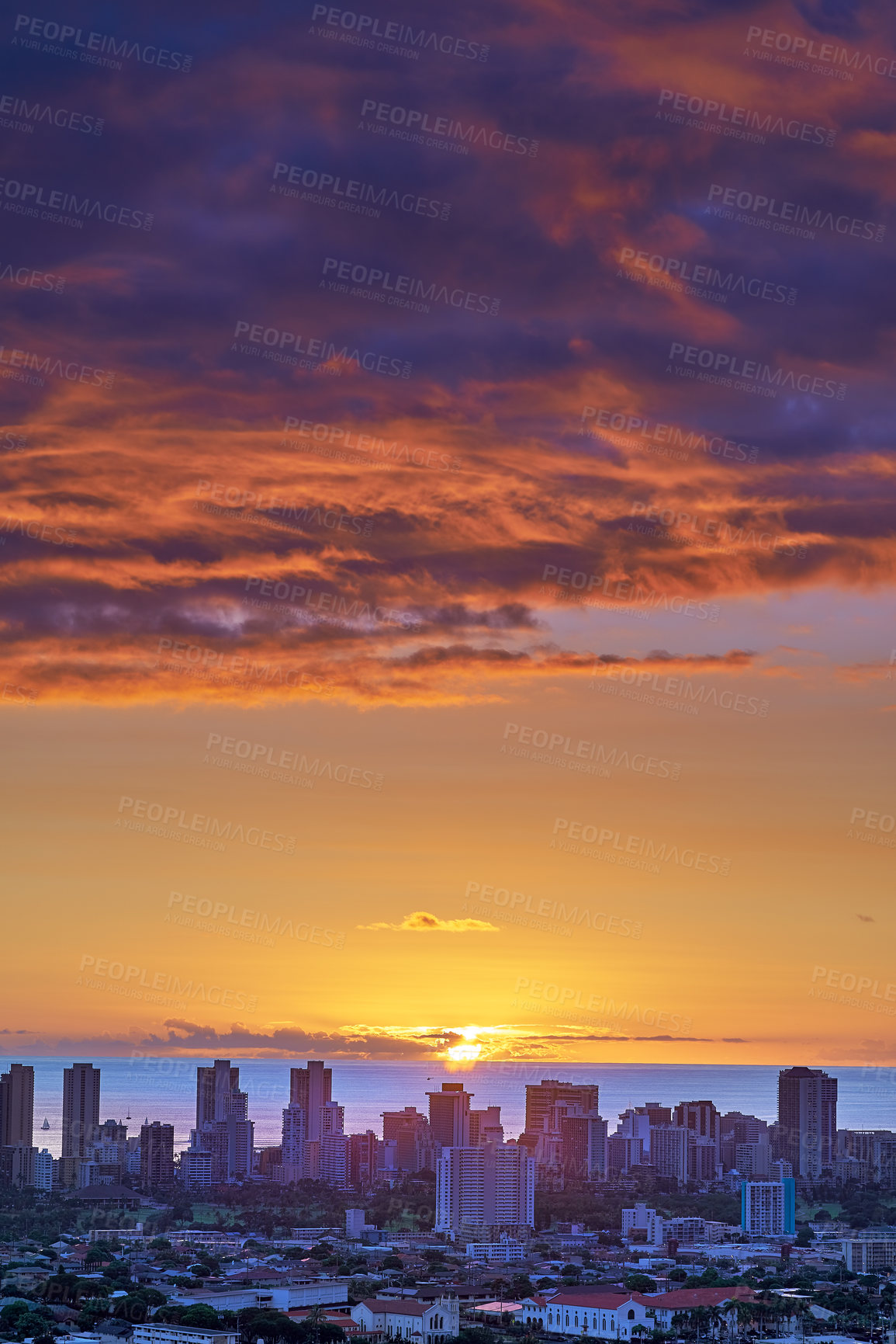 Buy stock photo A sunset over a city skyline near the sea with cloudy purple and orange sky. Sunrise over a blue horizon near urban landscape with copy space. Peaceful holiday destination at night in Waikiki, Hawaii