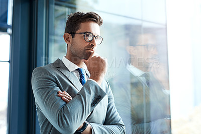 Buy stock photo Cropped shot of a professional businessman looking thoughtful while standing in his office