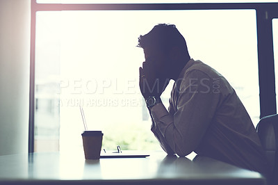 Buy stock photo Shot of a businessman looking stressed while sitting at his desk