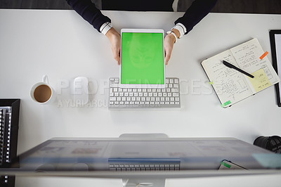 Buy stock photo Aerial shot of an unrecognizable young businesswoman sitting at her desk and using her tablet in a modern office