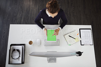 Buy stock photo Aerial shot of an unrecognizable young businesswoman sitting at her desk and using her tablet in a modern office