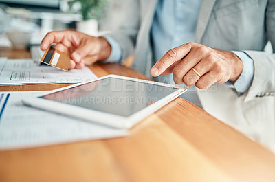Buy stock photo Closeup shot of an unrecognizable businessman using a digital tablet while holding a credit card in an office