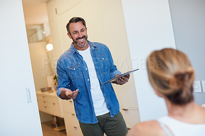 Buy stock photo Cropped shot of an attractive mature man talking to his wife while holding a digital tablet in their bedroom