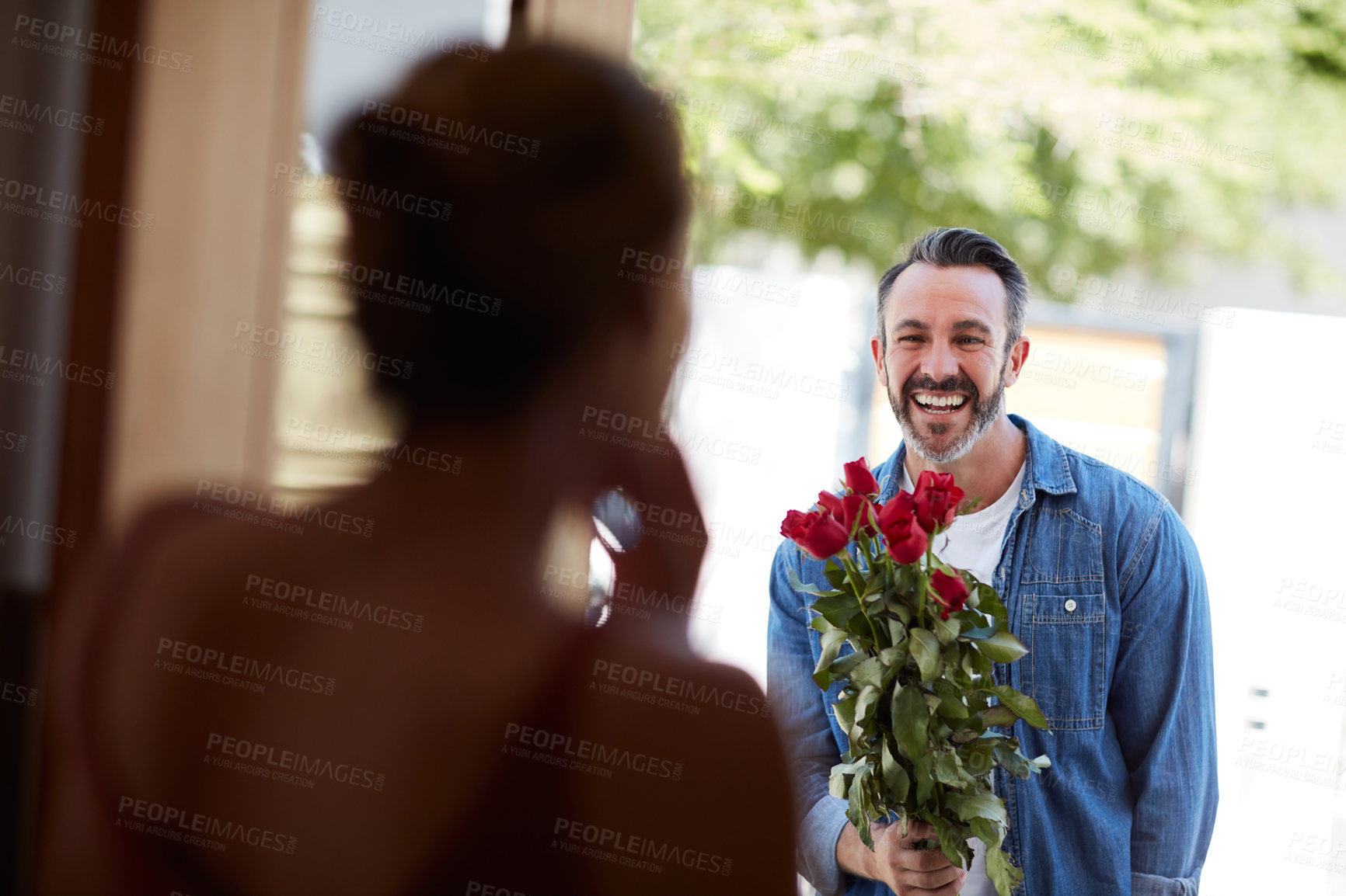 Buy stock photo Cropped shot of an attractive mature man surprising his girlfriend with a bouquet of roses