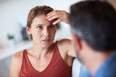 Buy stock photo Cropped shot of an attractive young woman looking dismayed while having a serious conversation with her husband