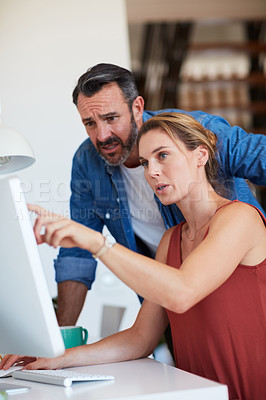 Buy stock photo Cropped shot of an attractive young woman having a discussion with her husband while sitting on a computer at home