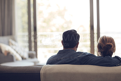 Buy stock photo Rearview shot of an unrecognizable couple relaxing on their couch at home