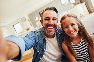 Buy stock photo Shot of an adorable little girl taking selfies with her father at home
