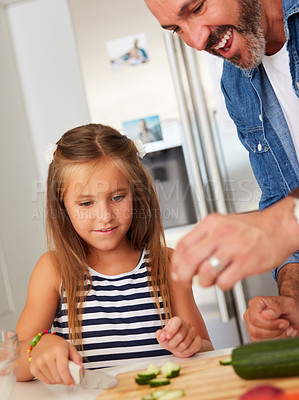 Buy stock photo Shot of an adorable little girl cooking with her father at home
