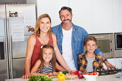 Buy stock photo Shot of a happy young family cooking together at home